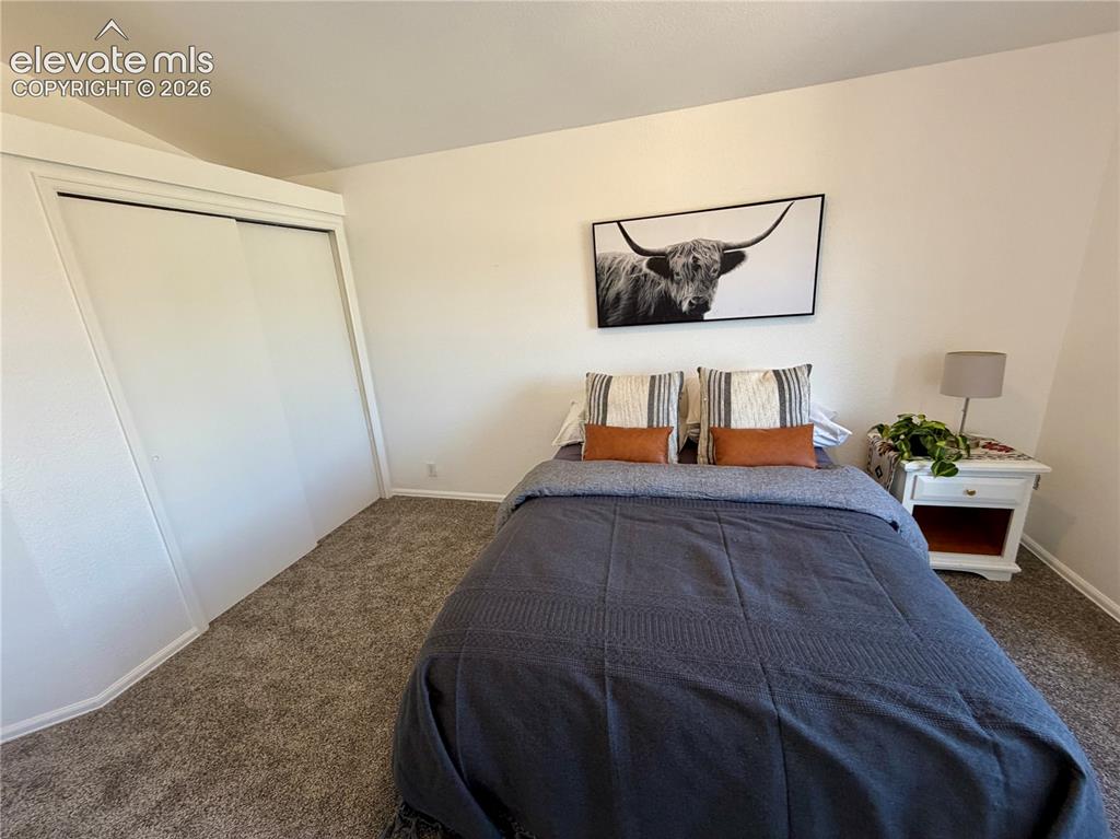 Image 21 of 50: Upstairs Bedroom featuring neutral wall tones, textured carpet flooring, an