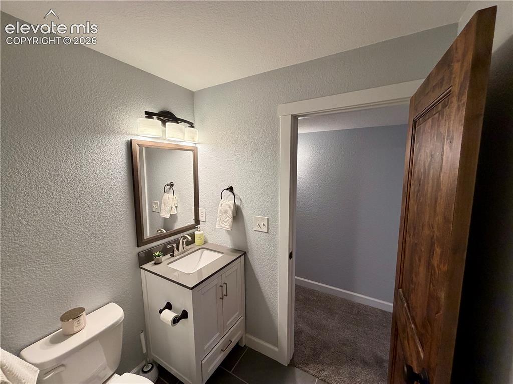 Image 34 of 50: Basement Bathroom-Vanity area featuring a single-sink vanity with white cab