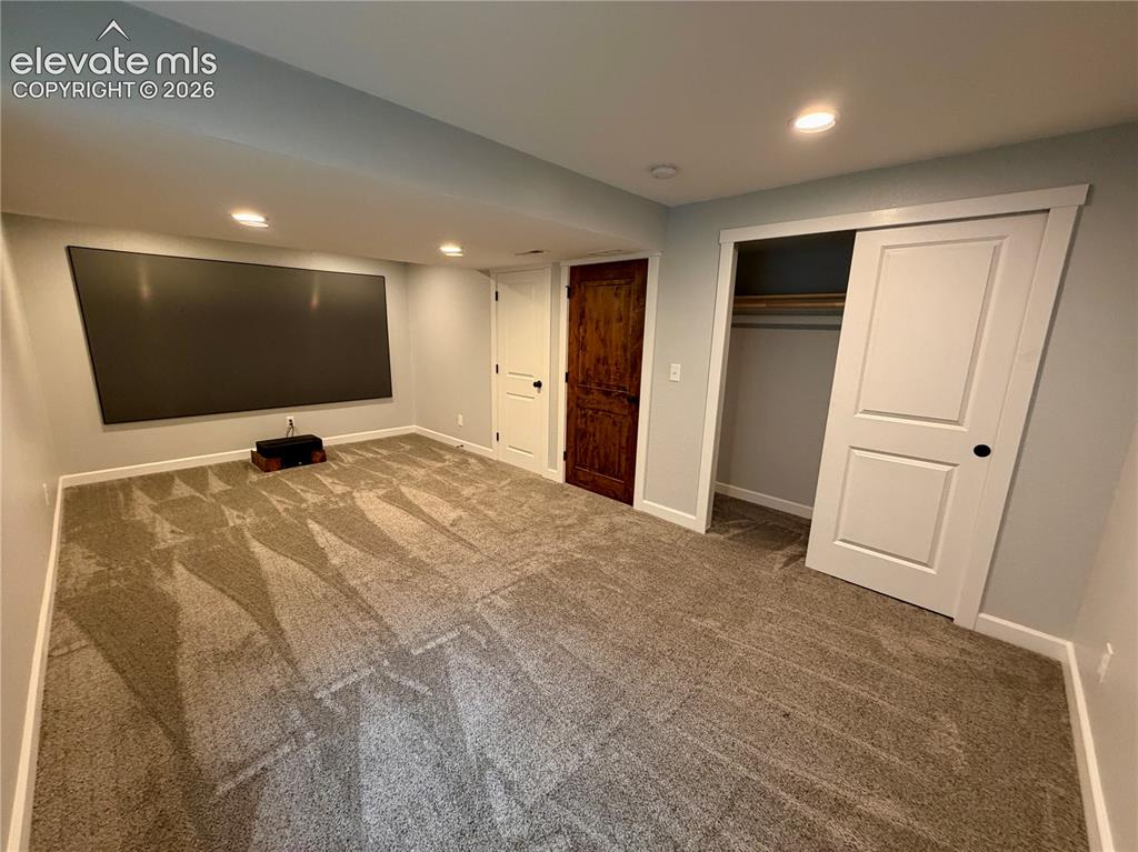 Image 37 of 50: Picture with furniture removed. Wall-mounted projection screen above neutra