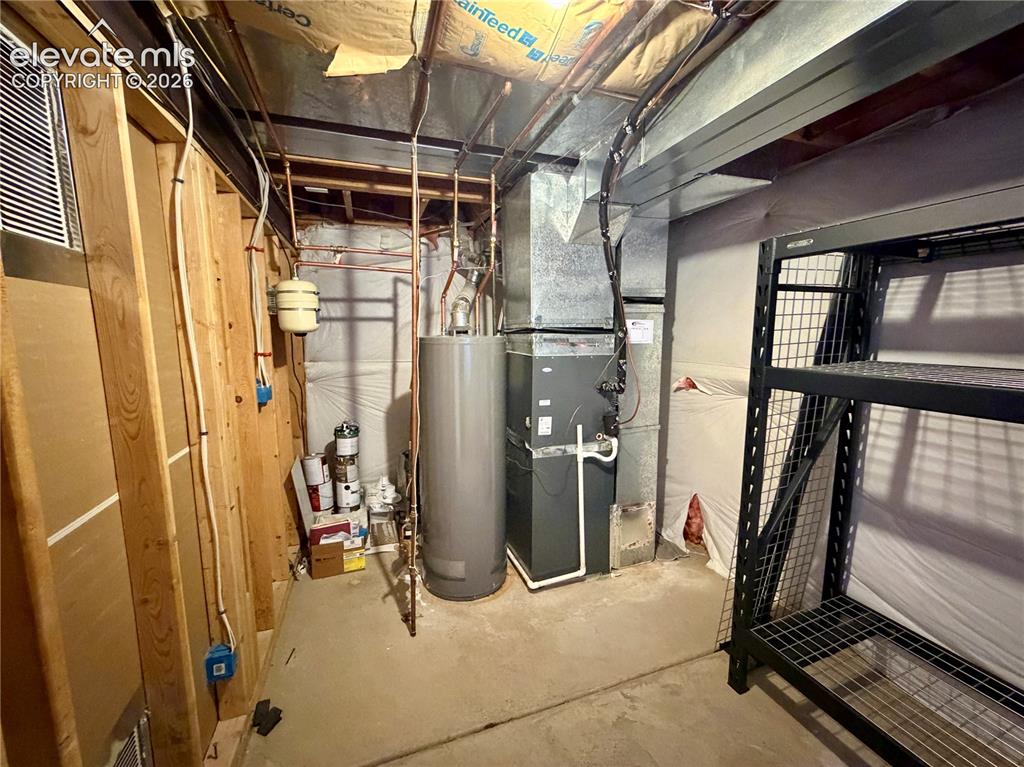 Image 42 of 50: Dedicated utility area featuring a water heater, furnace system, copper pip
