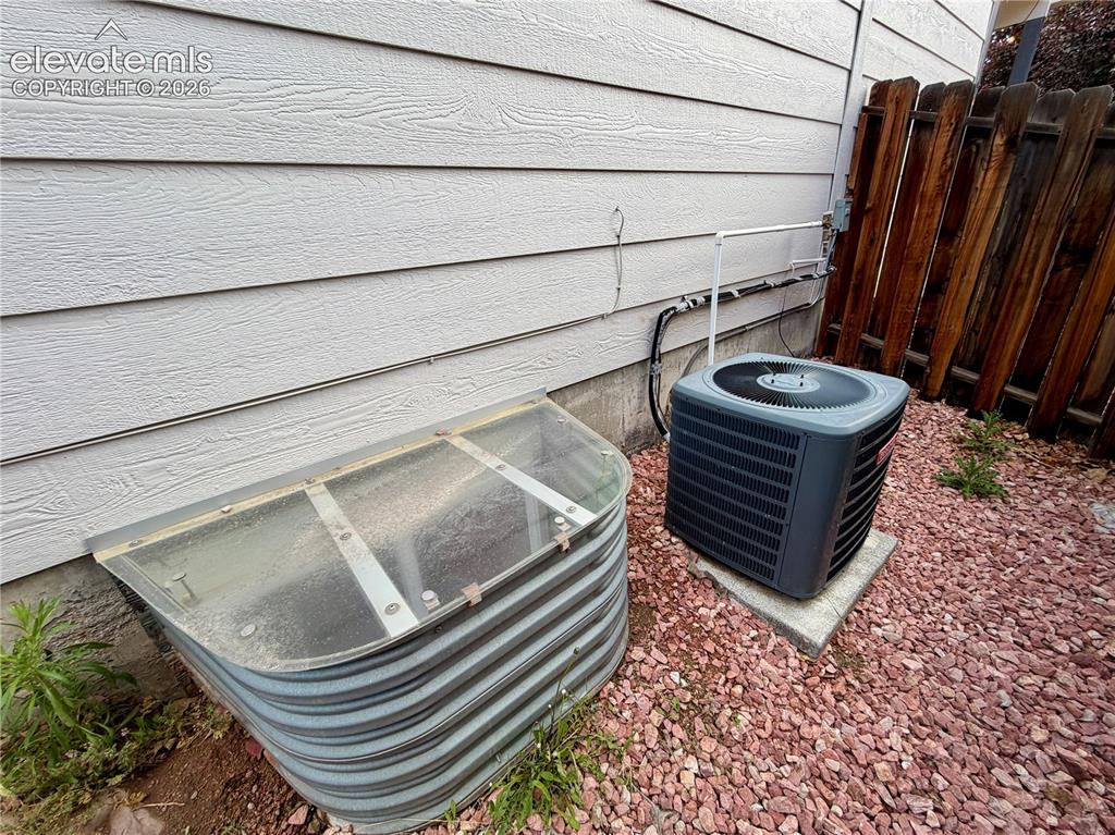 Image 43 of 50: Exterior siding with a window well featuring a clear cover