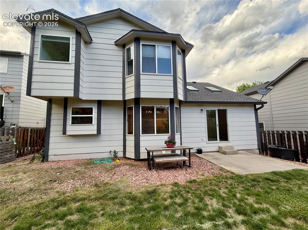 Image 46 of 50: Rear exterior featuring light-colored horizontal siding and dark trim accen