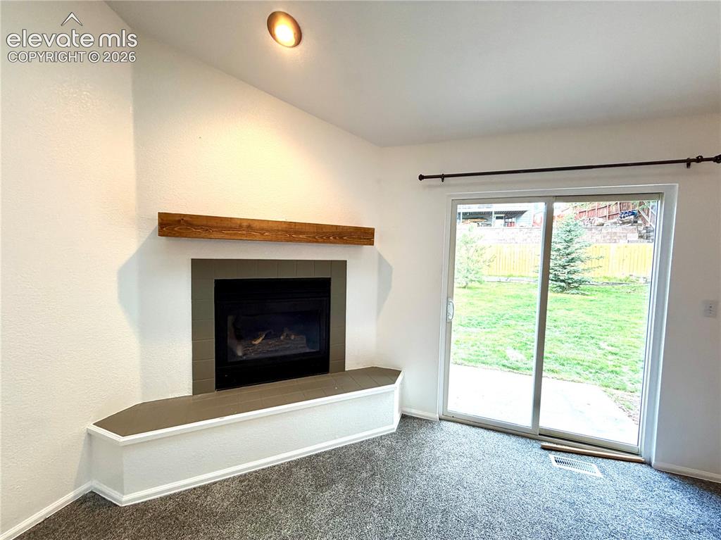 Image 5 of 50: Corner fireplace featuring a wood-finish mantel and a built-in hearth