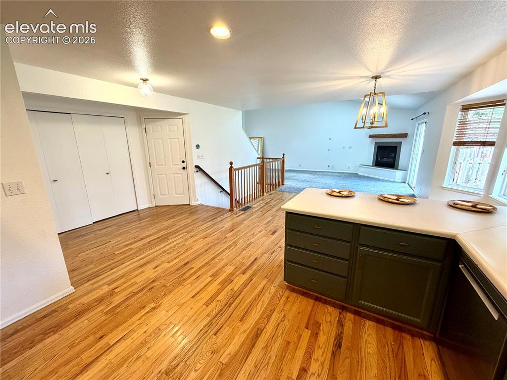 Image 9 of 50: Open-concept living space featuring wood-finish flooring, extensive counter