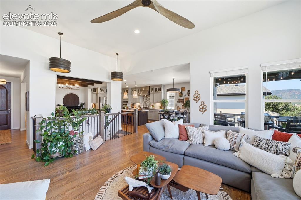 Image 15 of 50: Floor to ceiling windows with oversized walnut propeller ceiling fan