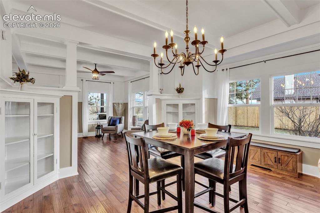 Image 10 of 43: Dining area featuring wood-finish flooring, a coffered ceiling, and a bronz