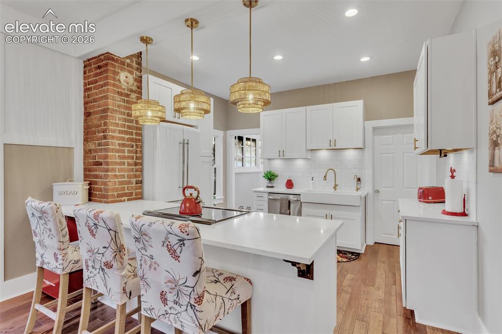 Image 11 of 43: Open-concept kitchen featuring white cabinetry, a large kitchen island with