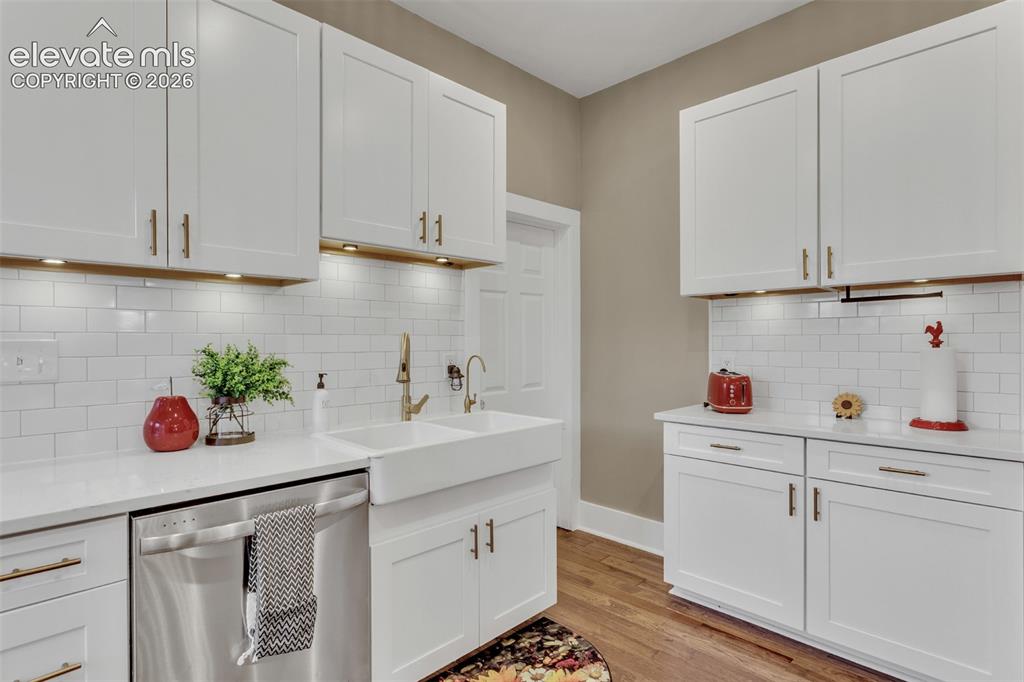 Image 15 of 43: Kitchen featuring white shaker-style cabinetry, a white subway tile backspl