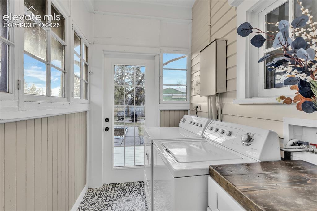 Image 16 of 43: Laundry area featuring patterned floor tiles, beadboard wainscoting, multi-