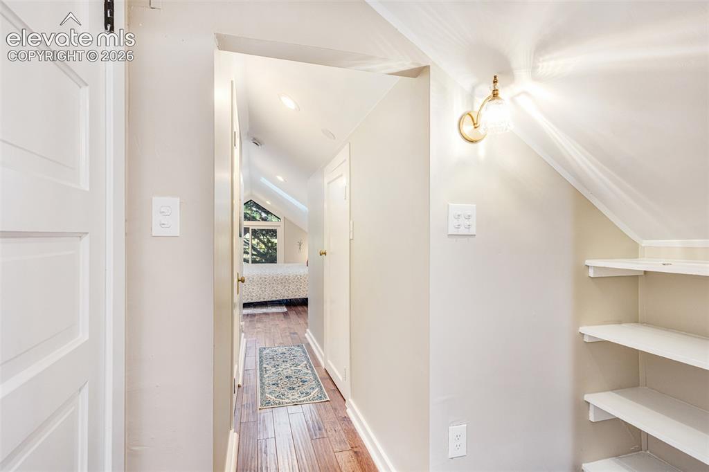 Image 19 of 43: Hallway with wood-finish flooring, recessed lighting, and a wall-mounted sc
