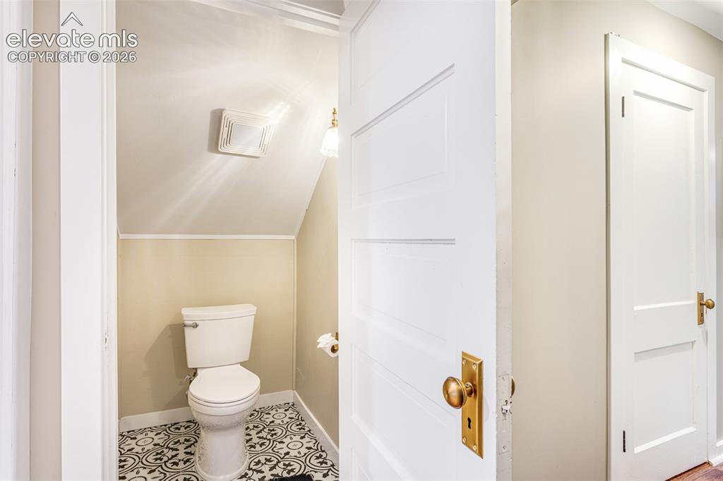 Image 20 of 43: Compact powder room featuring a patterned tile floor, white toilet, and bei