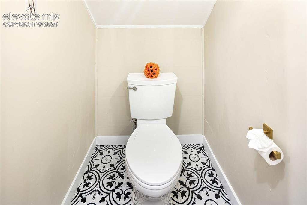 Image 21 of 43: Bathroom featuring a toilet with a decorative patterned tile floor, light n