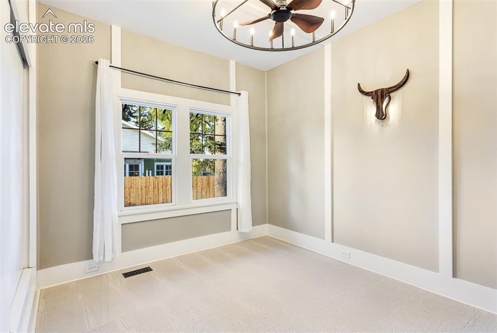 Image 27 of 43: Room featuring a double window, baseboard trim, wall paneling, and neutral