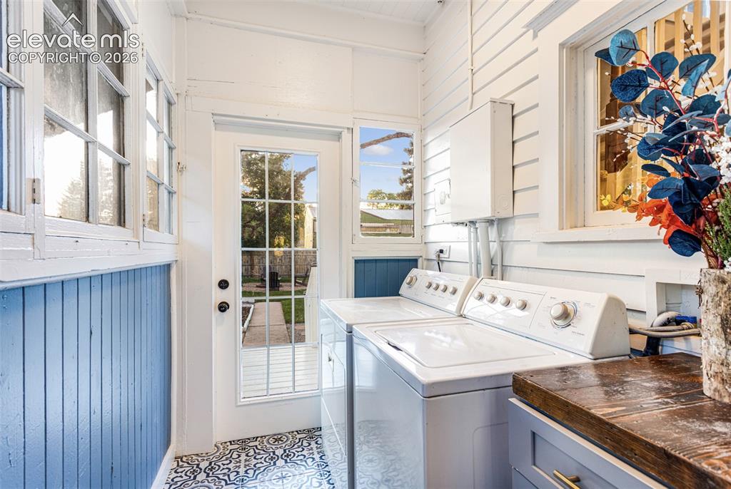 Image 32 of 43: Bright utility area featuring a glass-paned exterior door, multiple casemen