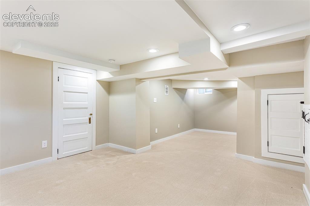 Image 35 of 43: Spacious room featuring neutral carpeting, light-toned walls, and white tri