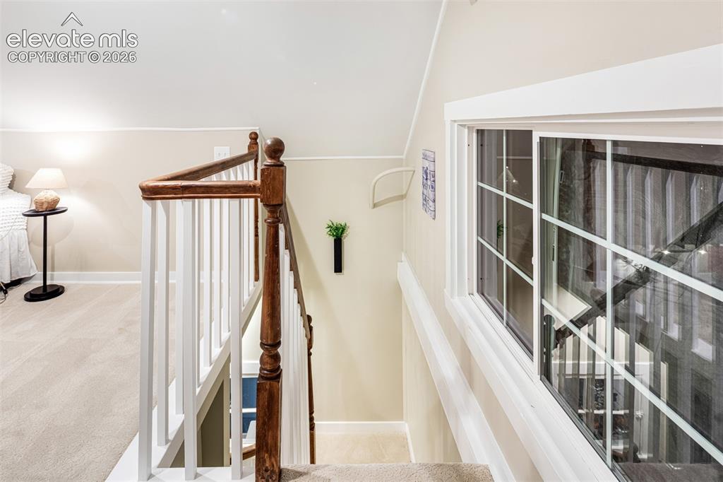 Image 39 of 43: White baluster railing with a polished wood-finish handrail