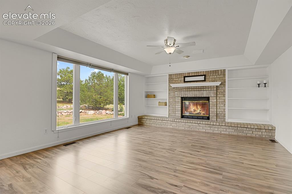 Image 5 of 35: Cozy wood burning fireplace with built-ins