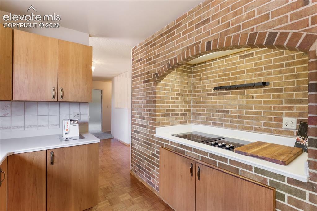 Image 13 of 47: Kitchen with brick archway around cooktop and oven