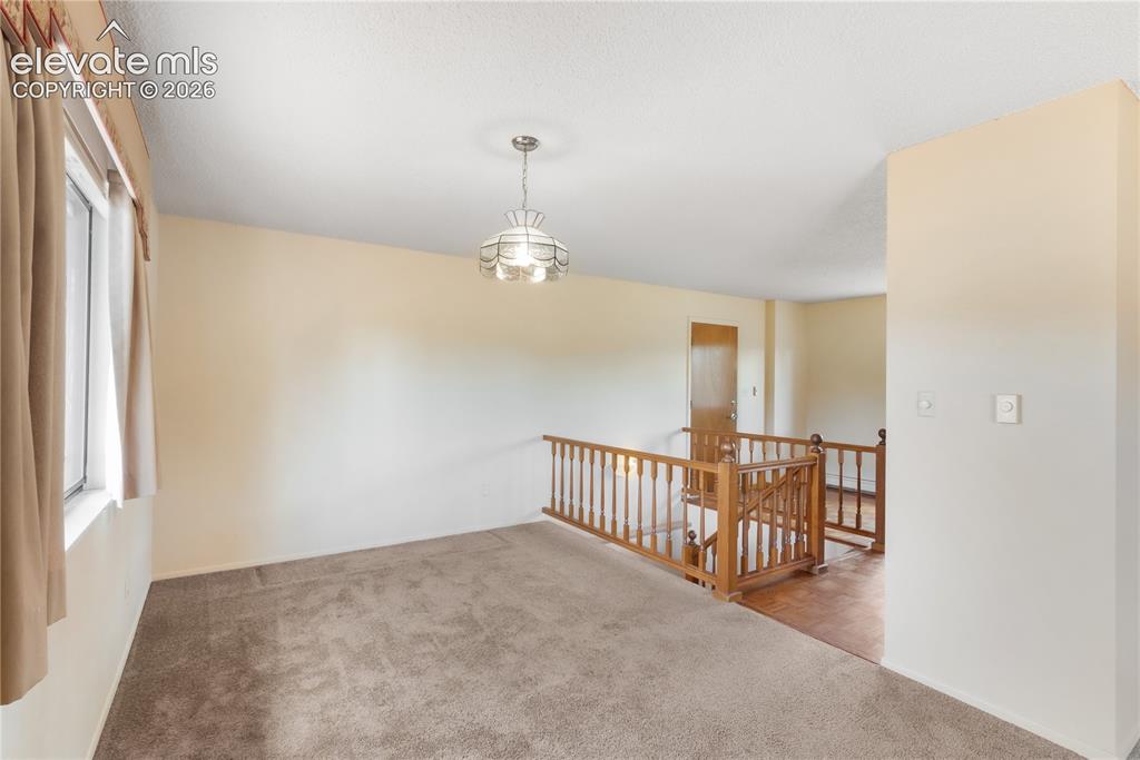 Image 18 of 47: Dining area and living room looking toward the kitchen, stairs to basement