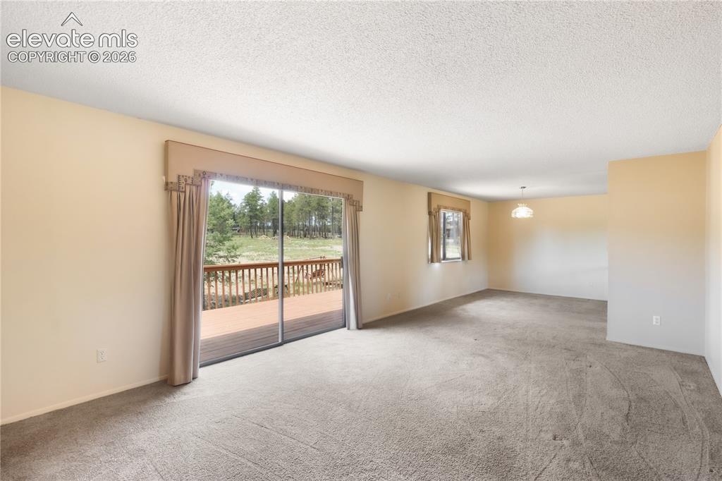 Image 19 of 47: Dining area looking from living room, stairs to basement to the right