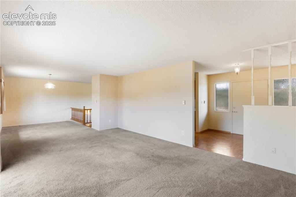 Image 20 of 47: Living room with door to the deck, dining area at the back