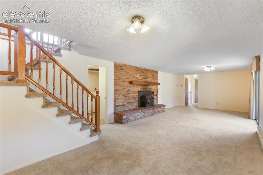 Image 27 of 47: Basement family room with wood burning stove
