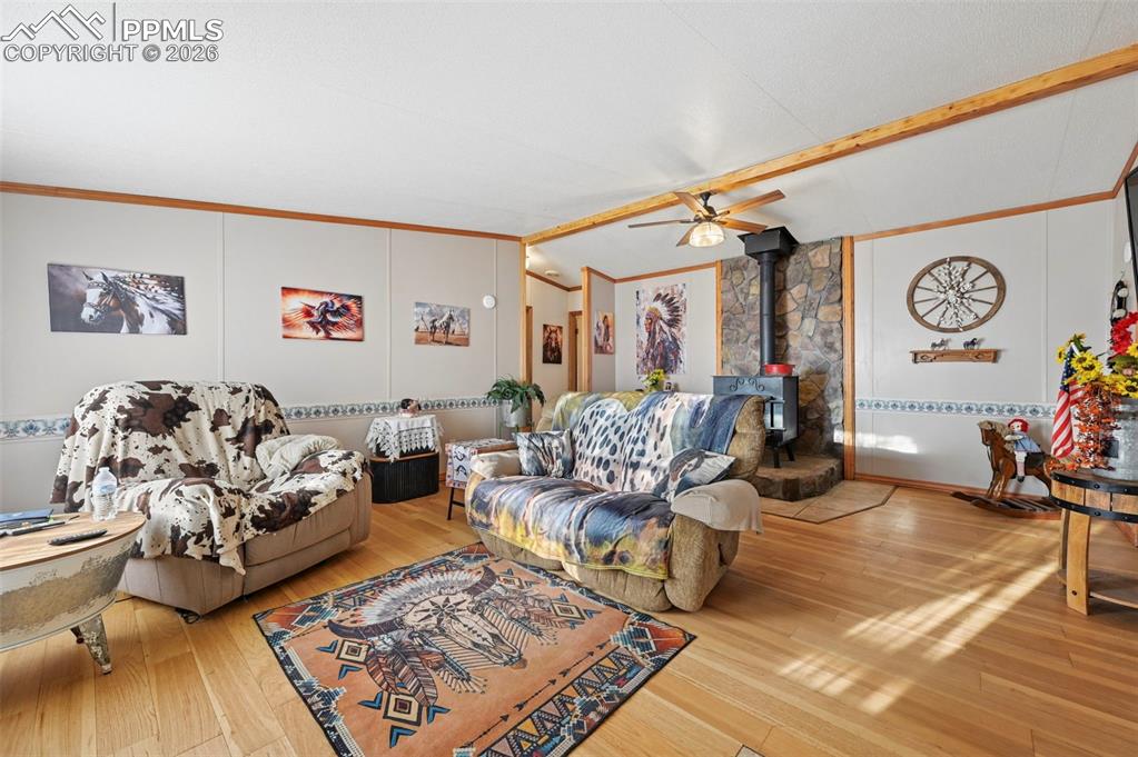 Image 14 of 45: Bright living area with vaulted ceilings and wood-burning stove 