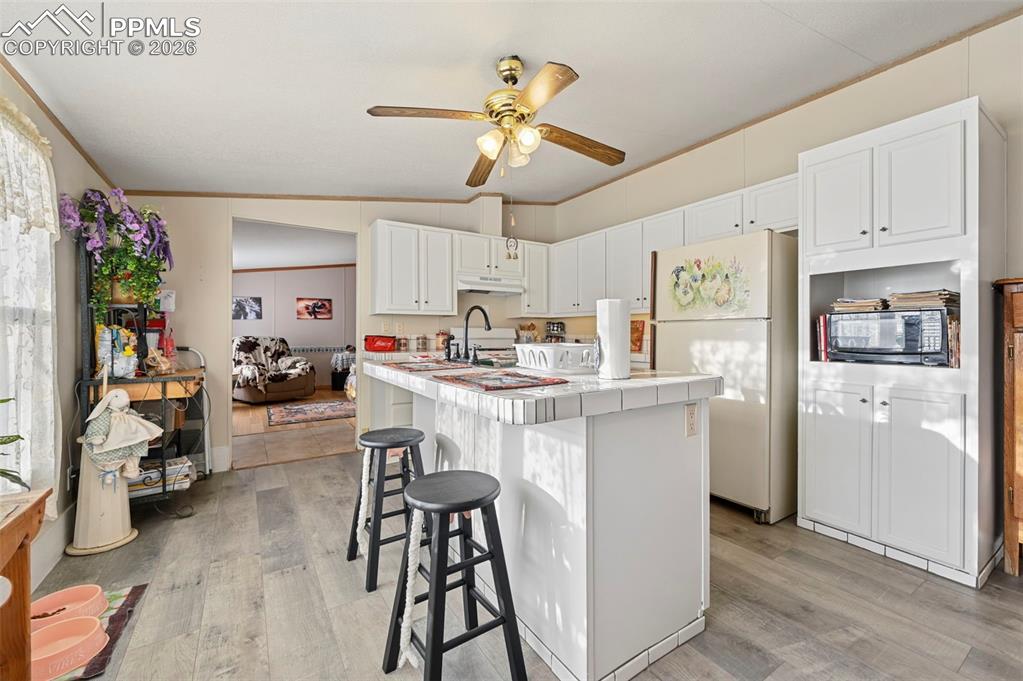 Image 18 of 45: Functional kitchen layout with abundant cabinetry and natural light 