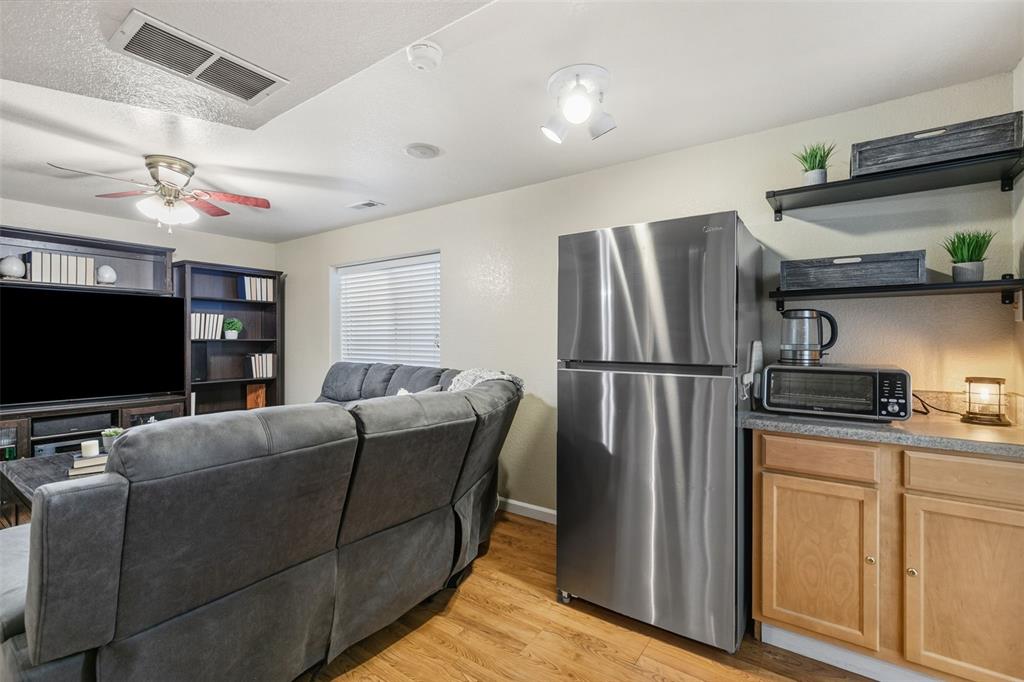 Image 22 of 30: FAMILY ROOM IN BASEMENT WITH REFRIGERATOR AND CABINET FOR REFRESHMENTS