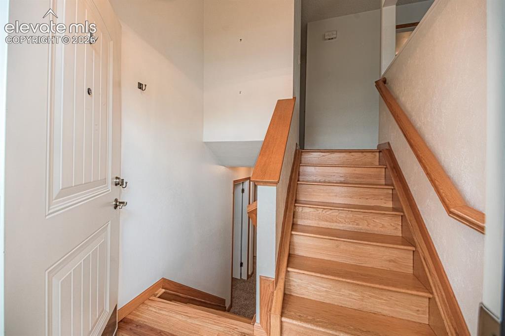 Image 12 of 34: Entryway featuring a paneled door, hardwood flooring, and a staircase with