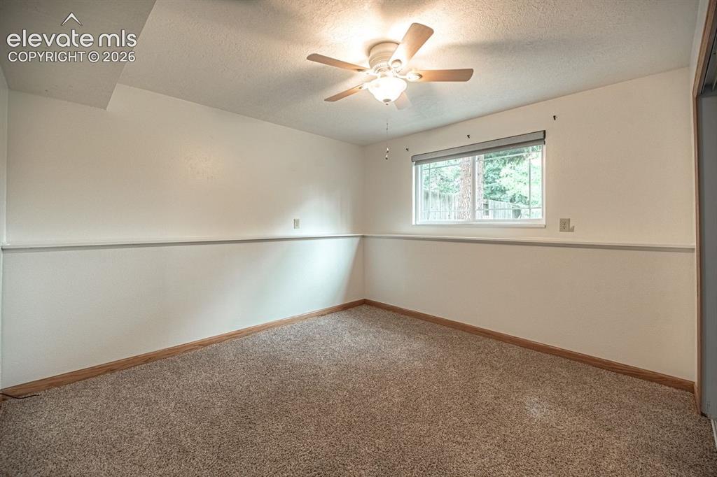 Image 17 of 34: Recessed window with roller shade, wood-finish flooring, and two-tone wall