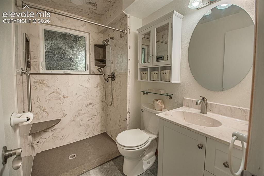 Image 19 of 34: Bathroom with walk in shower finished with marble.