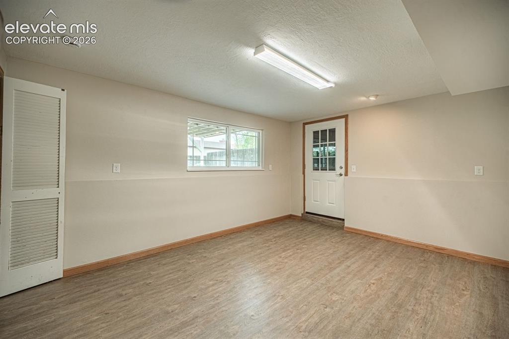 Image 25 of 34: Versatile room featuring wood-finish flooring, a multi-pane exterior door,