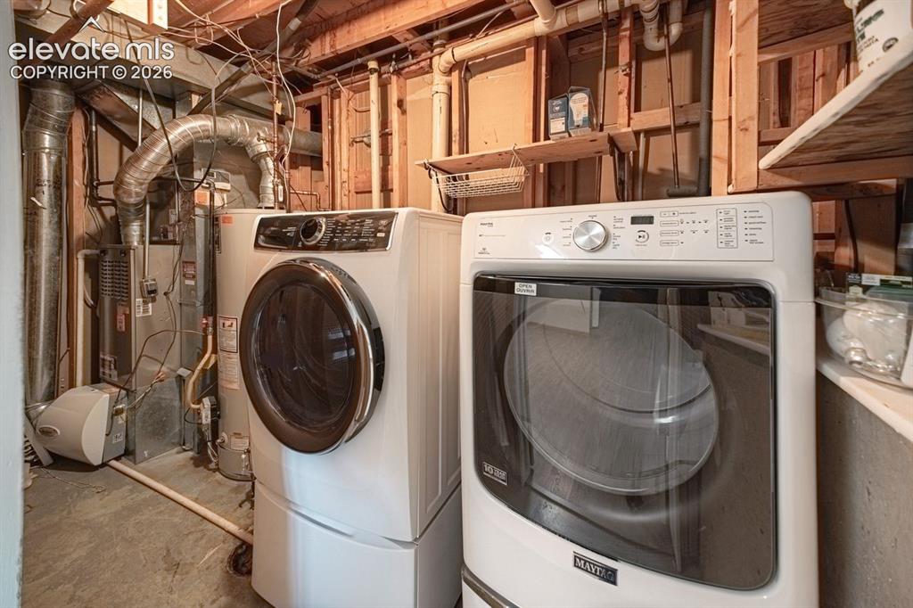 Image 27 of 34: Dedicated utility space featuring a front-load washer and dryer set, expose