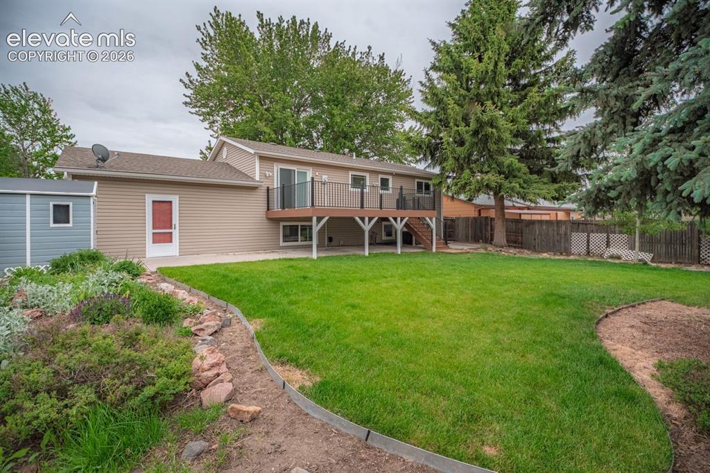 Image 30 of 34: Expansive backyard featuring a lush lawn, established trees, a multi-level