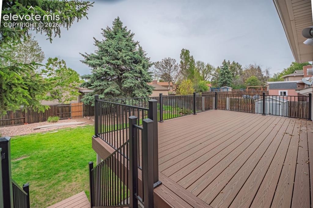 Image 32 of 34: Expansive composite deck featuring a durable wood-finish surface and black