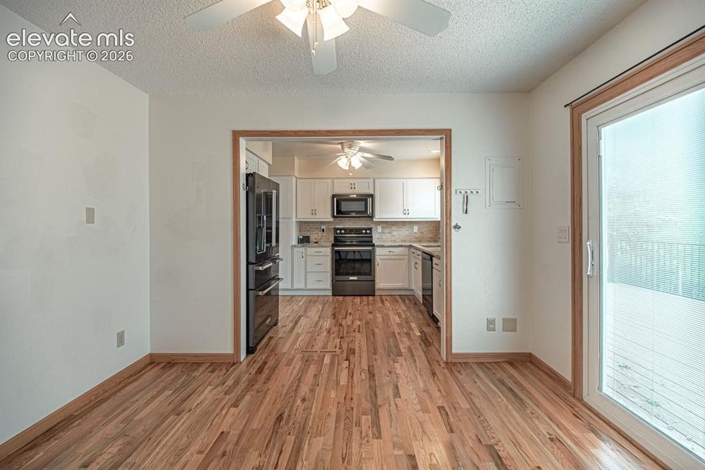 Image 5 of 34: Open-concept living space featuring ardwood flooring, a ceiling fan, and a