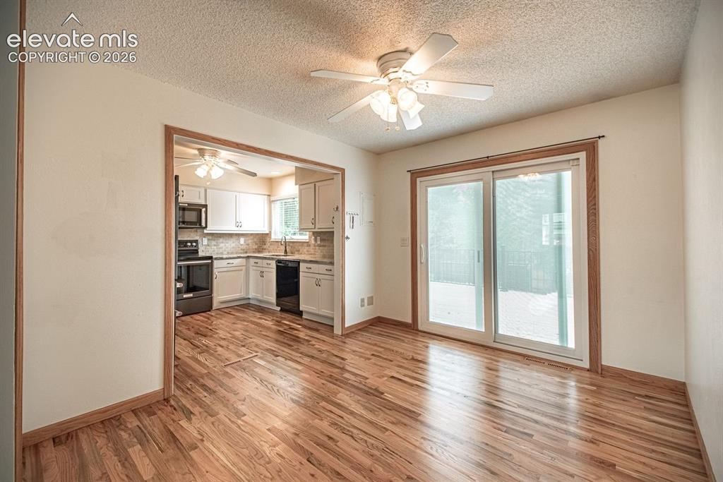 Image 6 of 34: Dining area featuring hardwood flooring, a ceiling fan, and a sliding glass
