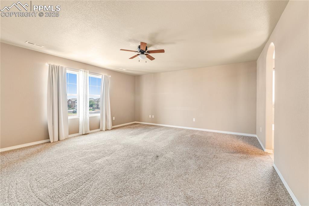 Image 17 of 43: Carpeted spare room featuring a textured ceiling and a ceiling fan