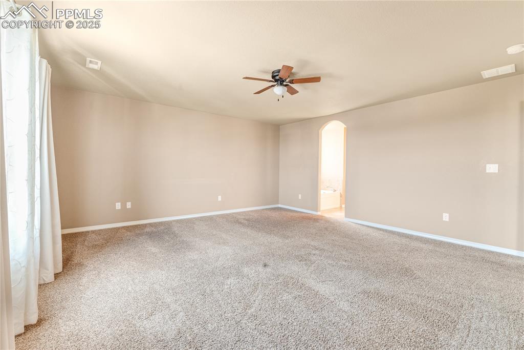 Image 18 of 43: Unfurnished room featuring light colored carpet, arched walkways, and ceili