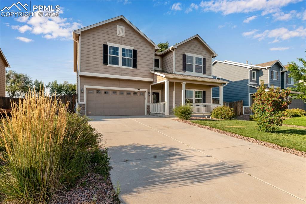 Image 2 of 43: Traditional home with a porch, an attached garage, concrete driveway, and s