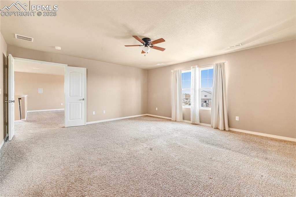 Image 20 of 43: Unfurnished room with carpet flooring, a ceiling fan, and a textured ceilin
