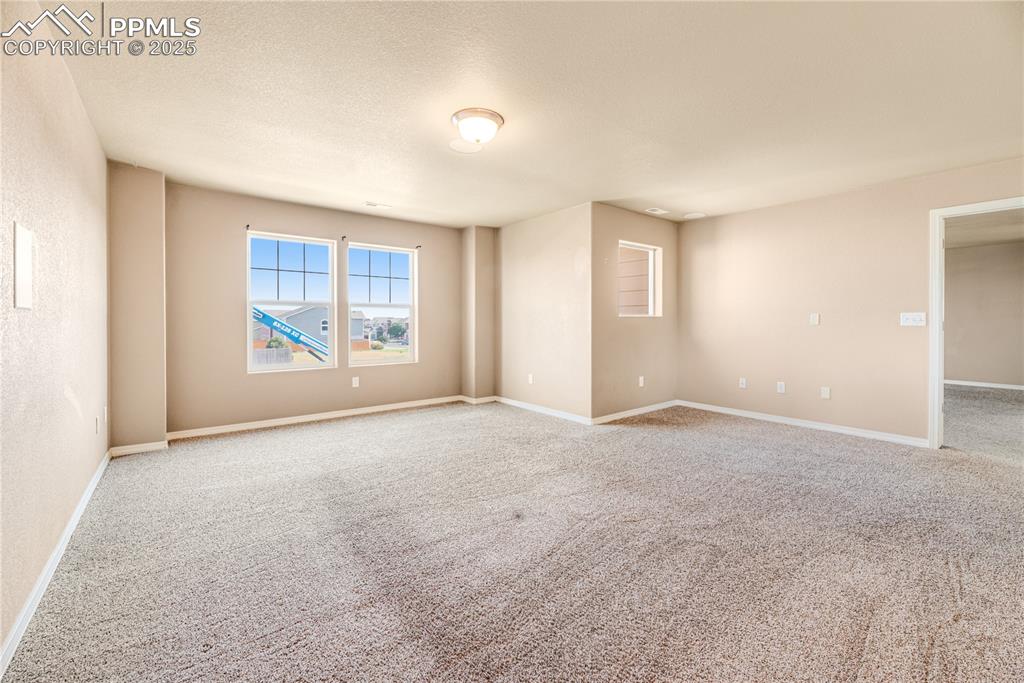 Image 27 of 43: Carpeted empty room with baseboards and a textured ceiling