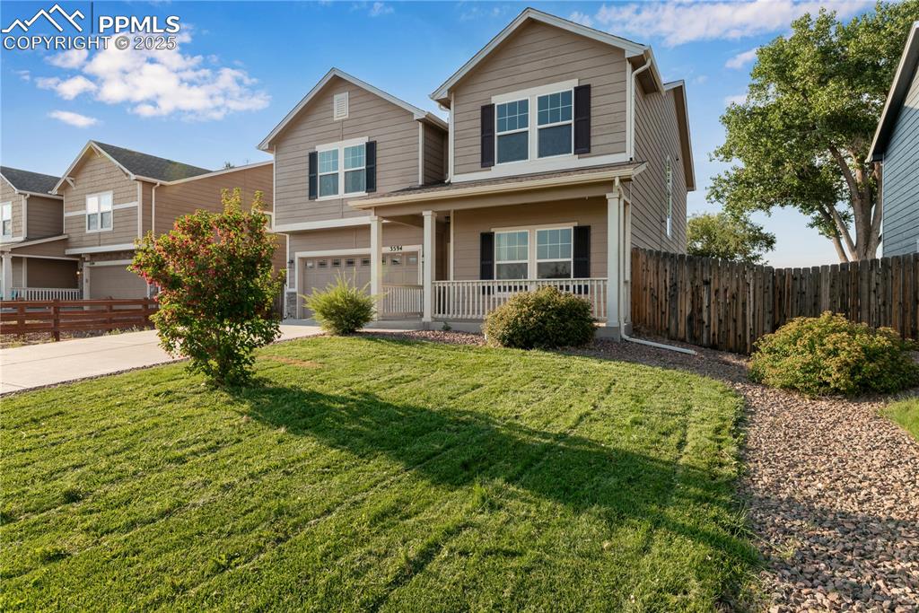 Image 3 of 43: Traditional-style home with covered porch, a garage, and driveway