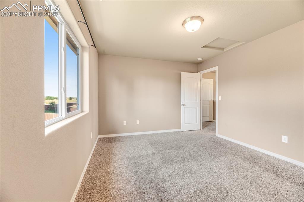 Image 34 of 43: Carpeted spare room with attic access and baseboards