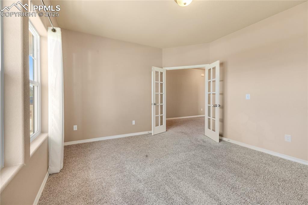 Image 39 of 43: Spare room featuring french doors and carpet floors