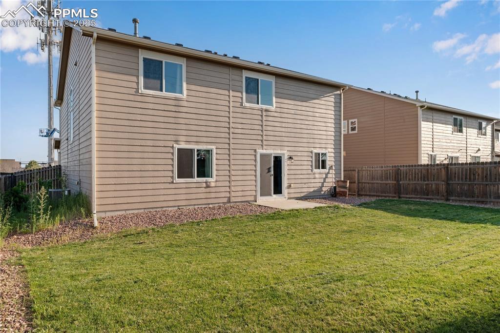 Image 43 of 43: Rear view of house with a fenced backyard