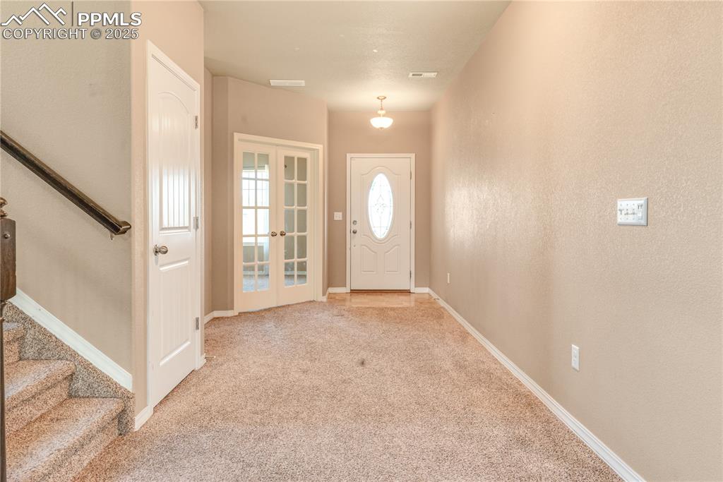 Image 5 of 43: Foyer entrance featuring stairs, light colored carpet, and french doors