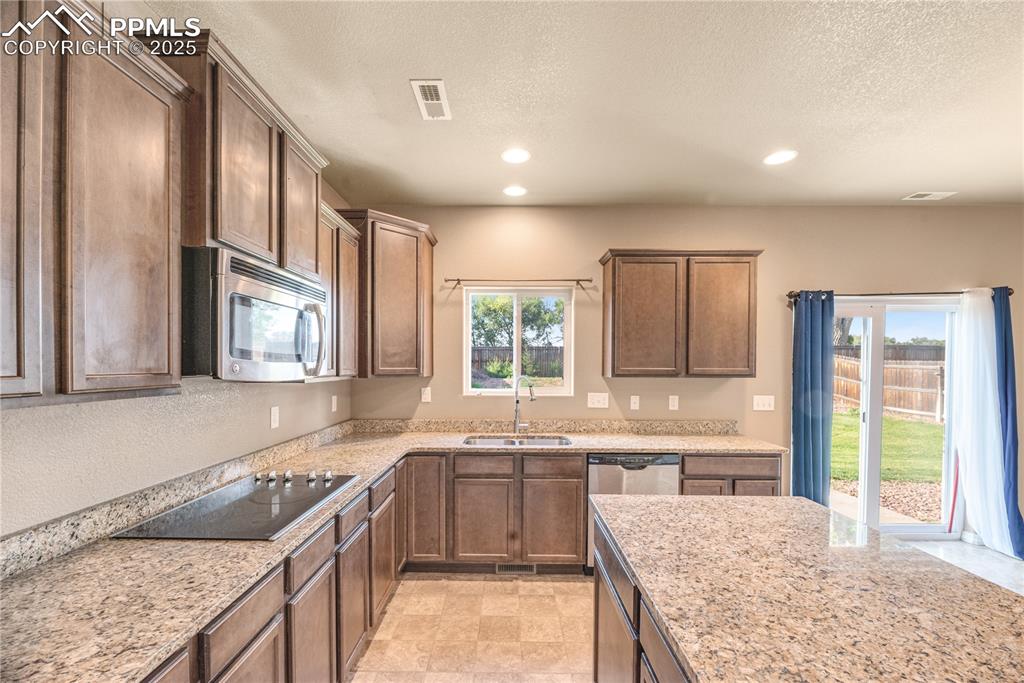 Image 7 of 43: Kitchen featuring recessed lighting, a textured ceiling, stainless steel ap