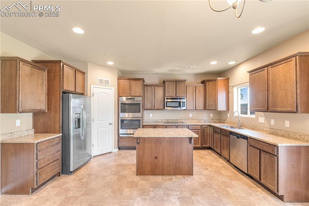 Image 8 of 43: Kitchen with a kitchen island, stainless steel appliances, recessed lightin